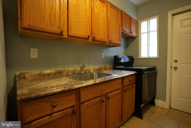 kitchen with black range with electric stovetop, sink, and light tile patterned flooring