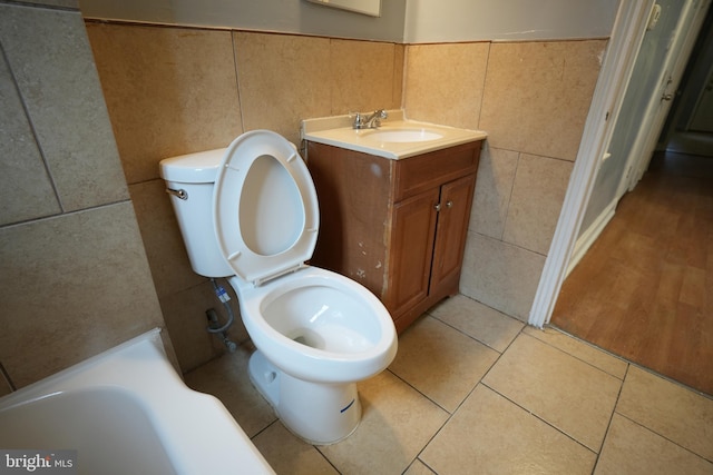 bathroom with vanity, tile walls, tile patterned floors, and toilet