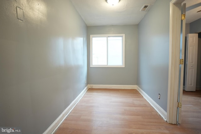 corridor featuring a textured ceiling and light wood-type flooring