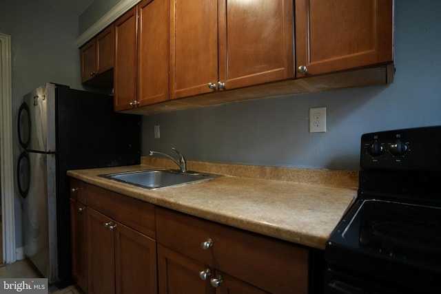 kitchen with black range with electric stovetop, sink, and stainless steel refrigerator