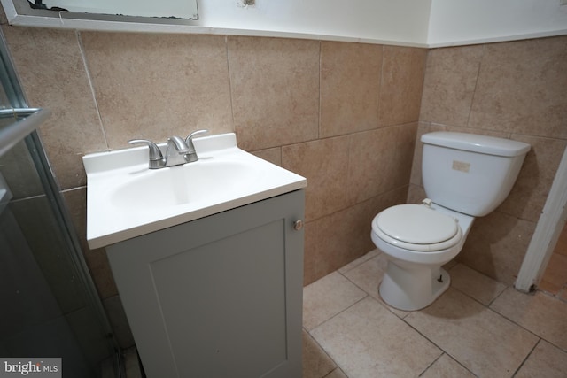 bathroom featuring vanity, tile walls, tile patterned floors, and toilet