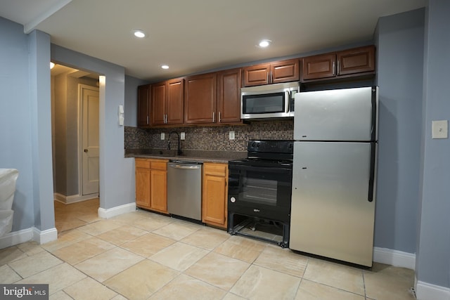 kitchen featuring stainless steel appliances, tasteful backsplash, sink, and light tile patterned floors