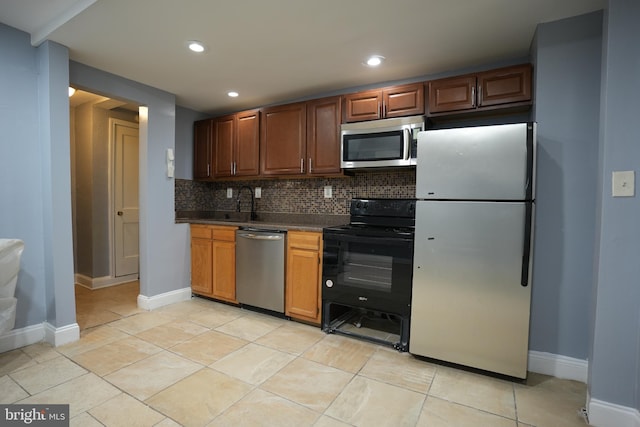 kitchen with stainless steel appliances, light tile patterned floors, and decorative backsplash