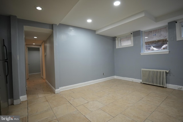 basement with radiator and light tile patterned floors