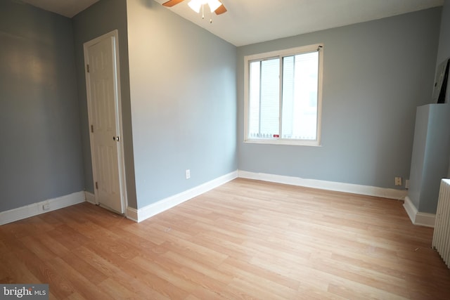 empty room featuring ceiling fan, vaulted ceiling, and light hardwood / wood-style floors