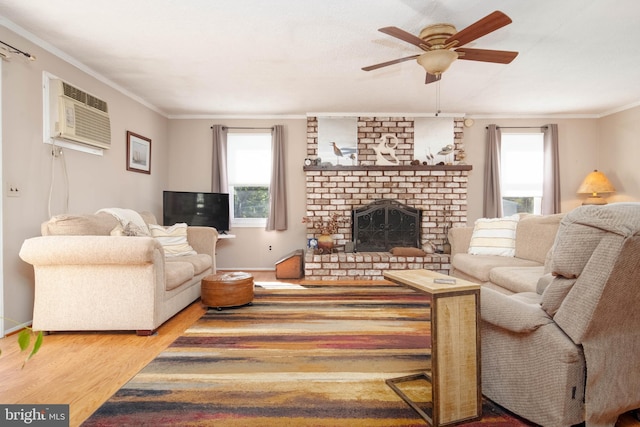 living room with a fireplace, a wall mounted AC, hardwood / wood-style flooring, ornamental molding, and ceiling fan