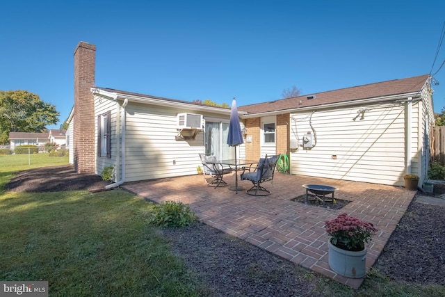 back of property featuring an outdoor fire pit, a lawn, a patio area, and an AC wall unit