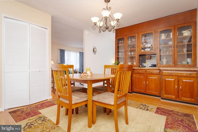 dining space with a chandelier and light hardwood / wood-style floors