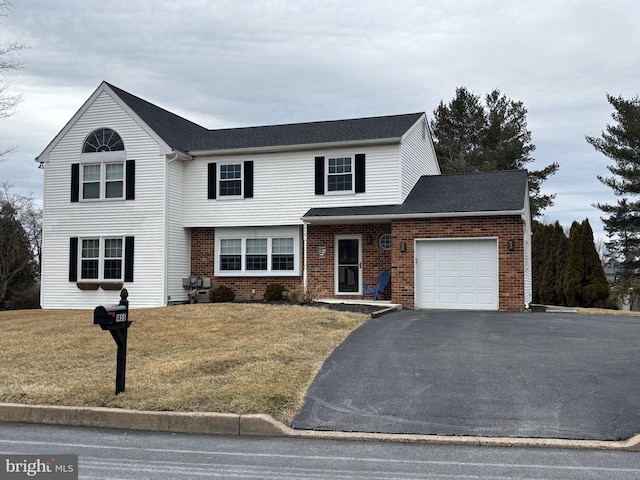 view of property featuring a garage and a front lawn