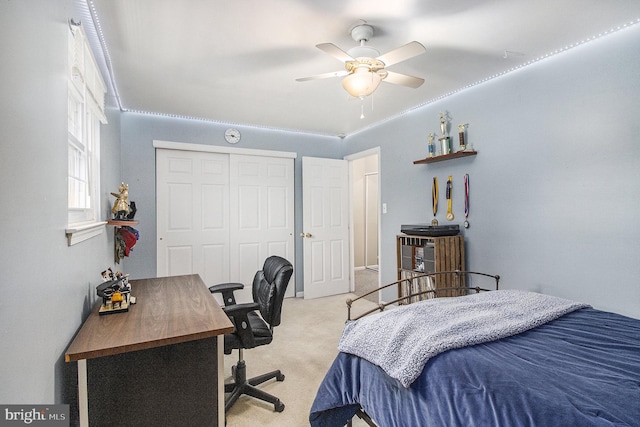 bedroom featuring ceiling fan, light colored carpet, and a closet