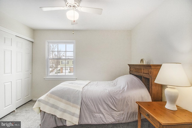 carpeted bedroom featuring ceiling fan and a closet