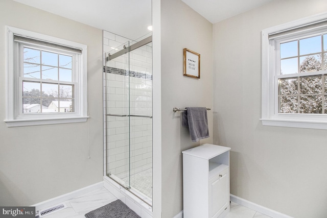 bathroom featuring an enclosed shower and a wealth of natural light