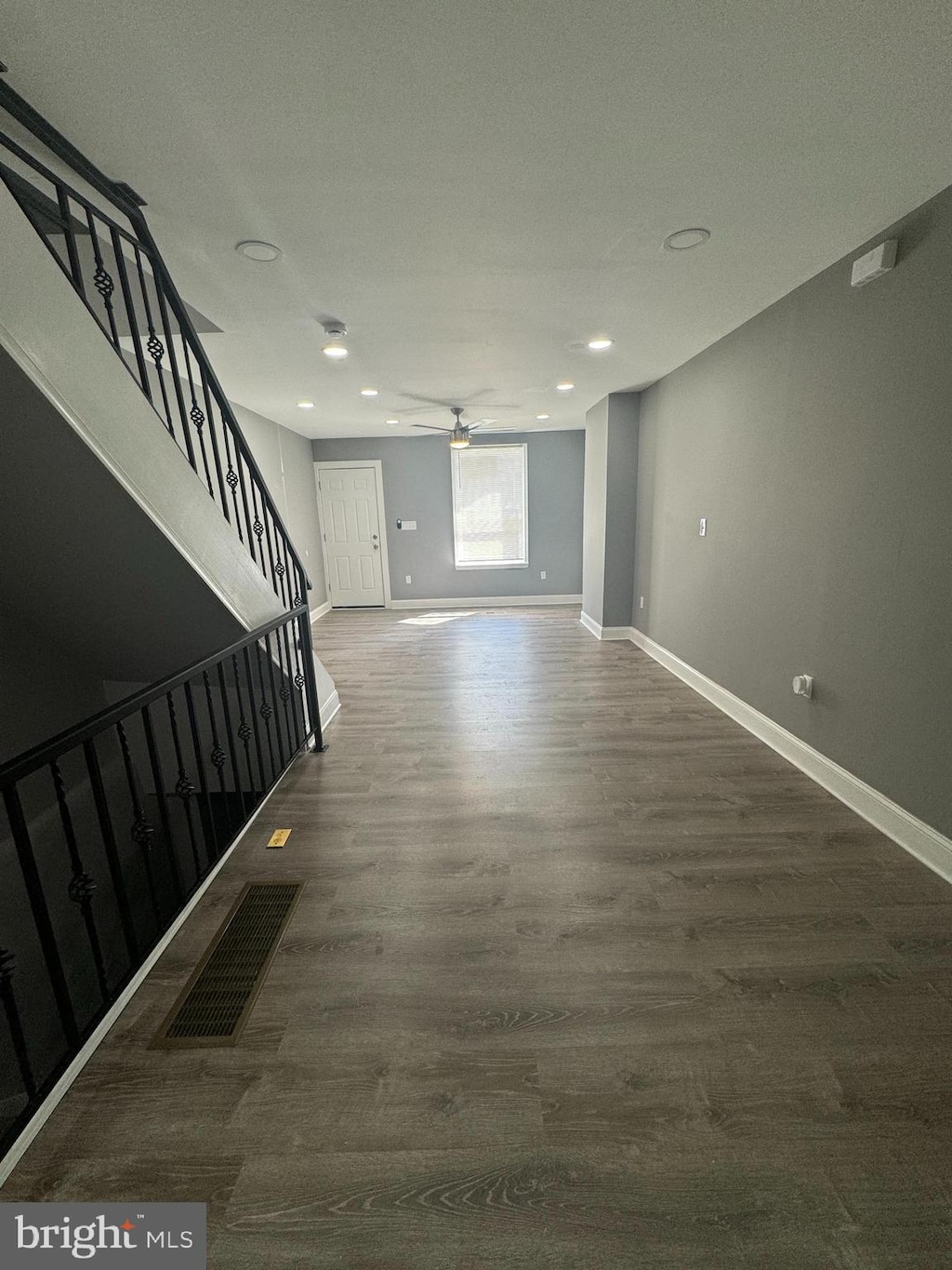 interior space with dark wood-type flooring and ceiling fan