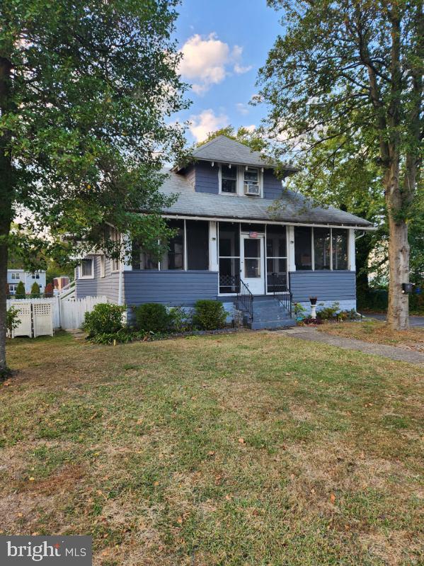 view of front of home with a sunroom and a front lawn