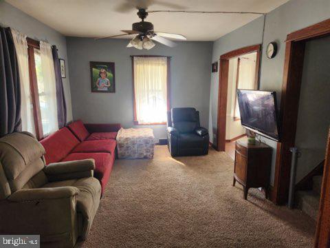 carpeted living room featuring ceiling fan