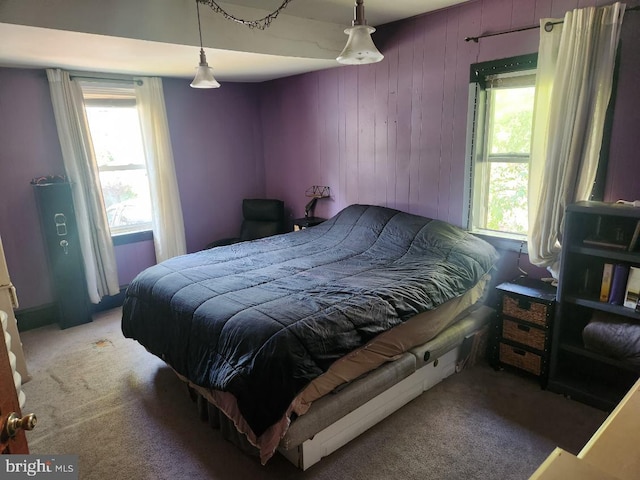 bedroom with wooden walls and carpet flooring