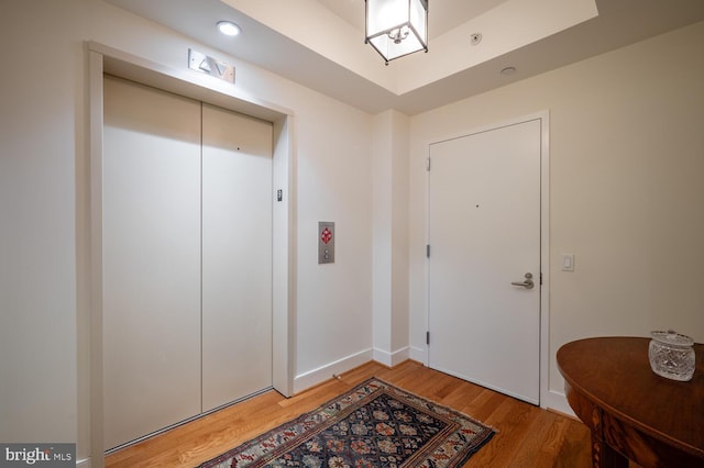 doorway to outside featuring hardwood / wood-style flooring and elevator