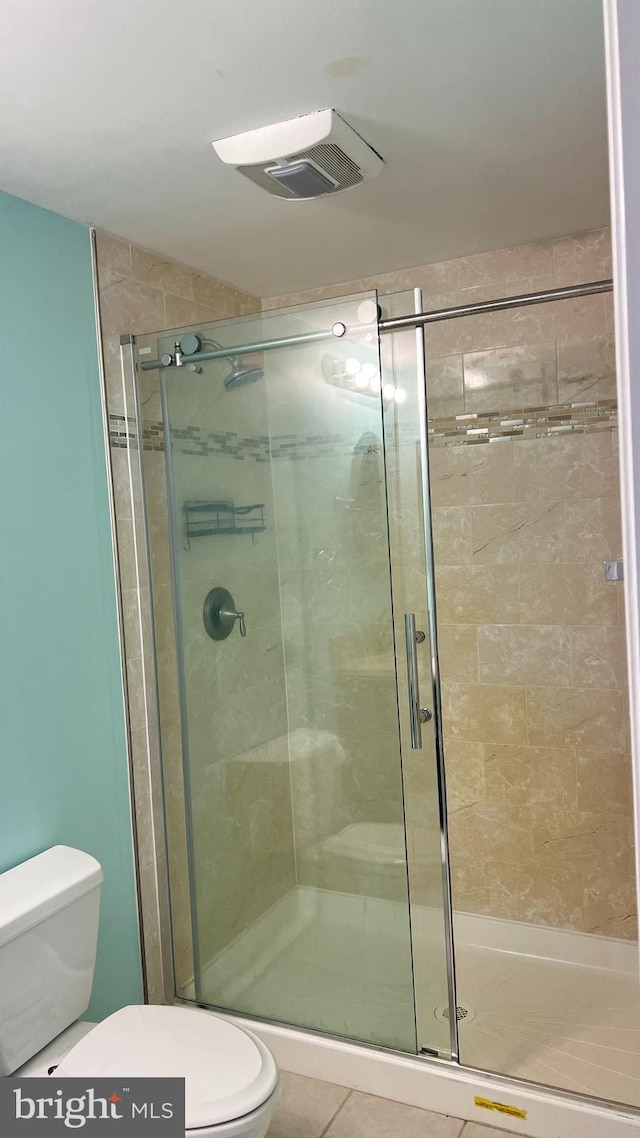 bathroom featuring visible vents, tile patterned flooring, a shower stall, and toilet