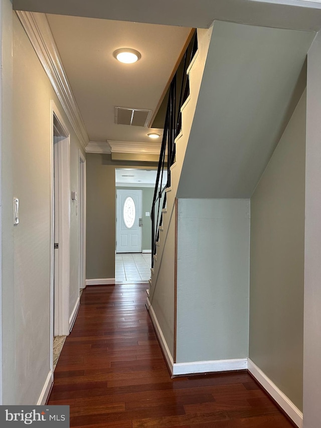 corridor with stairway, visible vents, ornamental molding, and dark wood finished floors