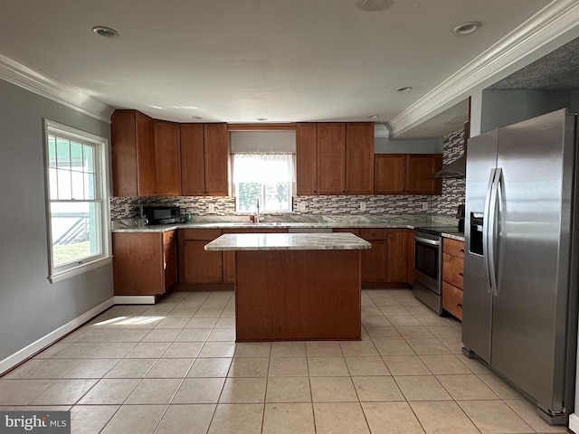 kitchen featuring a sink, stainless steel appliances, crown molding, and a center island