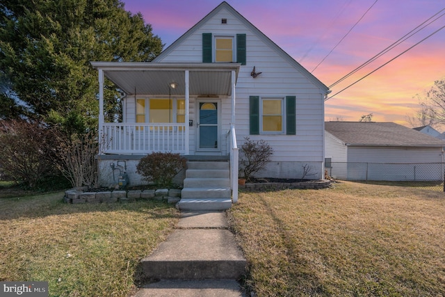 bungalow-style home with a yard, a porch, and fence