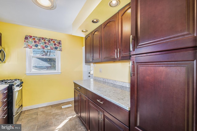 kitchen with light stone counters and stainless steel gas stove