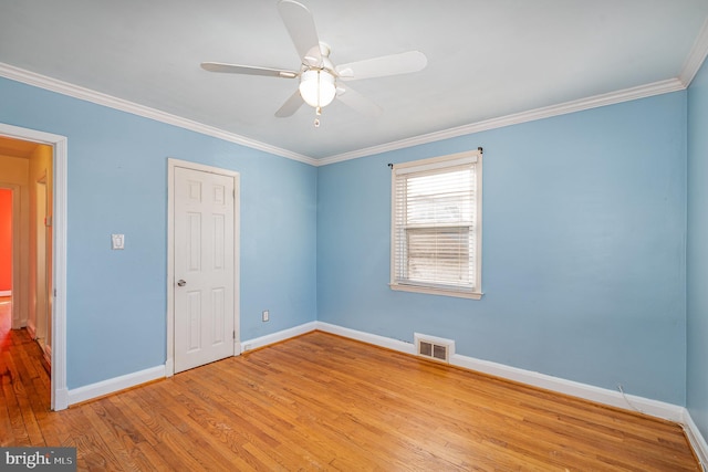 unfurnished bedroom with ceiling fan, wood finished floors, visible vents, baseboards, and ornamental molding