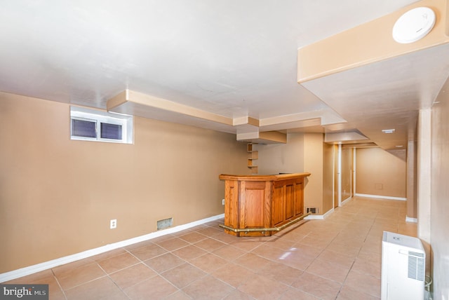 bar with a dry bar, light tile patterned flooring, and baseboards