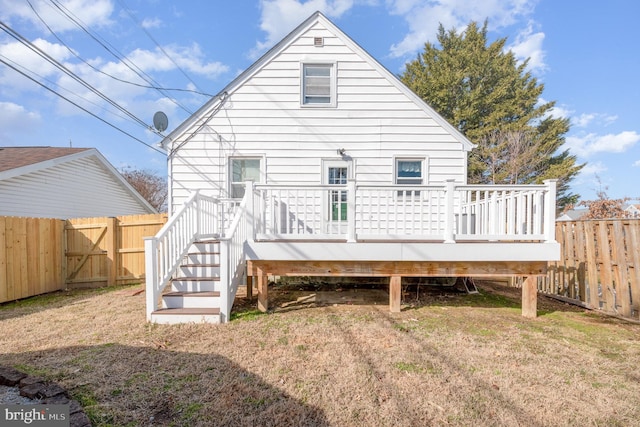 back of house with a fenced backyard, a gate, a deck, and a lawn