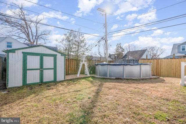 view of yard featuring a fenced backyard, a storage unit, a fenced in pool, and an outbuilding