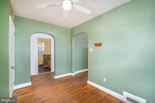 spare room with dark hardwood / wood-style flooring and ceiling fan