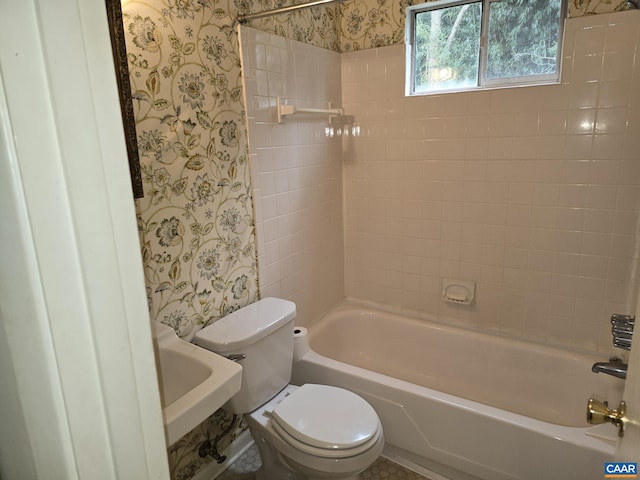 bathroom with tiled shower / bath combo and toilet