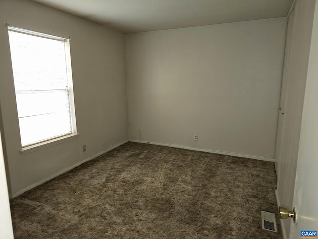 empty room with dark colored carpet