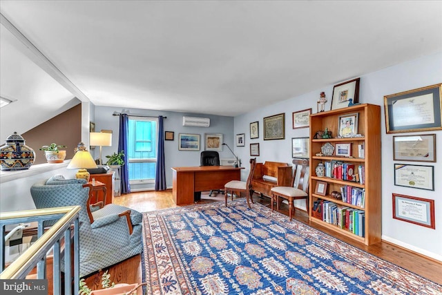 office space with hardwood / wood-style floors and a wall unit AC