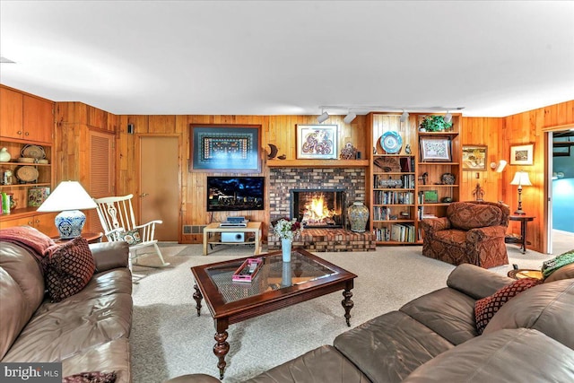 carpeted living room featuring wooden walls and a brick fireplace