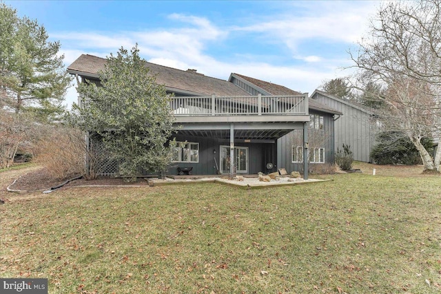 back of property with a wooden deck and a lawn