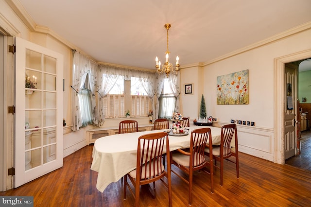 dining area featuring a chandelier, dark wood-type flooring, and ornamental molding