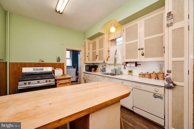 kitchen with washer / clothes dryer, wooden counters, white dishwasher, a sink, and stainless steel gas range oven