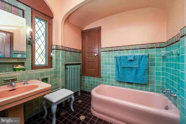 full bath with tile patterned flooring, radiator, tile walls, and a bath