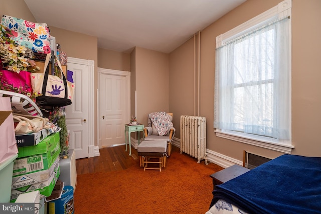 bedroom featuring radiator heating unit and wood finished floors