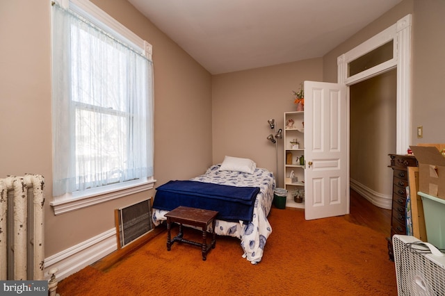 bedroom featuring radiator and baseboards