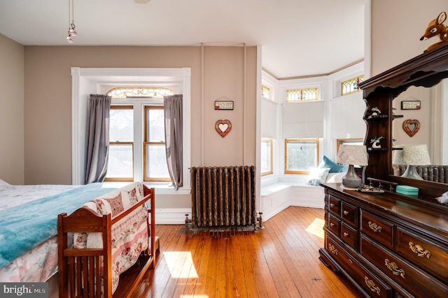 bedroom with light wood-style floors and radiator