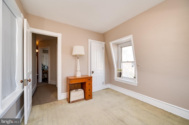 bedroom with baseboards and light colored carpet