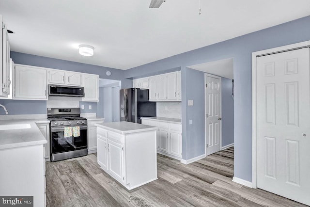 kitchen with stainless steel appliances, a center island, and white cabinets