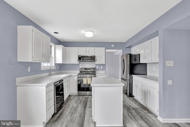 kitchen with sink, a center island, light wood-type flooring, appliances with stainless steel finishes, and white cabinets