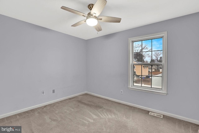 carpeted spare room featuring ceiling fan