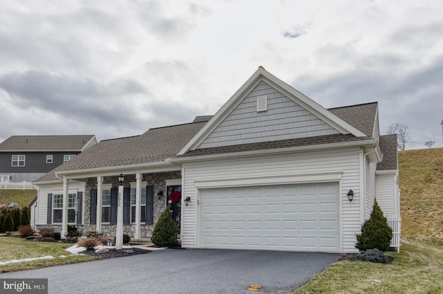 view of front of home featuring a garage, a front yard, and covered porch