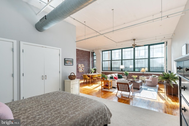 bedroom with a high ceiling and wood-type flooring