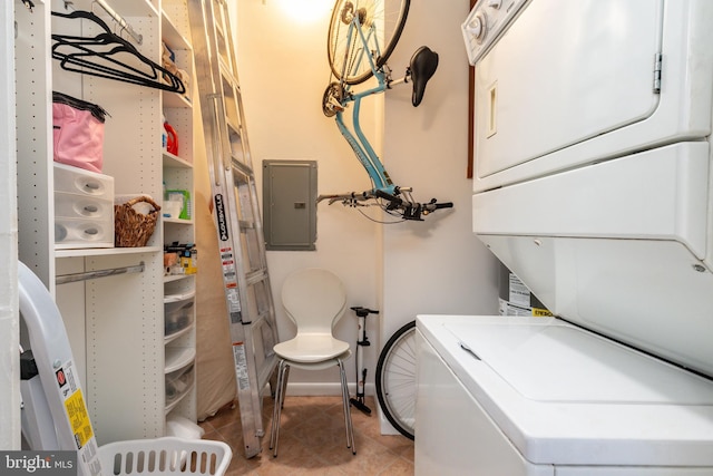 washroom featuring stacked washer and dryer, light tile patterned floors, and electric panel