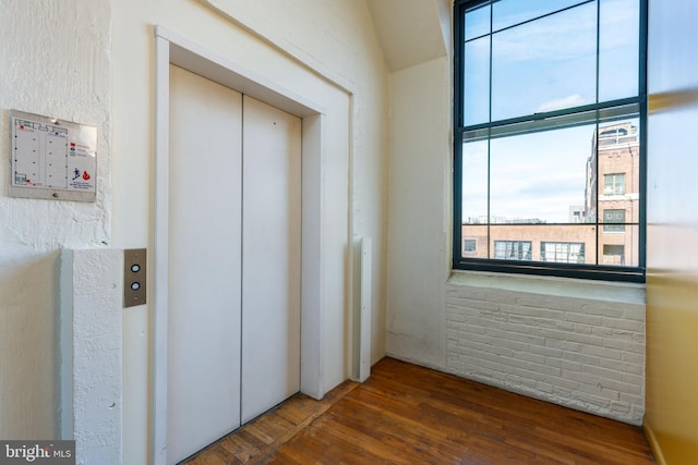 interior space with dark wood-type flooring and elevator